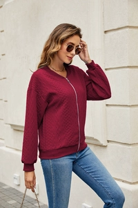 Detail of burgundy cable knit zip-up jacket with ribbed cuffs and high-quality texture