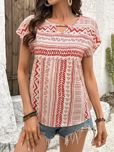 Detail of bohemian geometric print top with neckline button and tassel ties