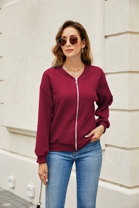 Detail of burgundy zip-up hoodie featuring a cable knit texture and ribbed cuffs