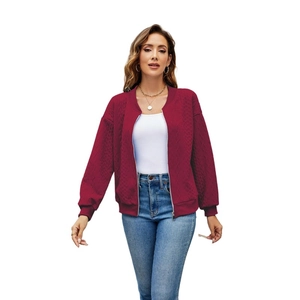 Detail of burgundy zip-up jacket with textured diamond pattern and ribbed cuffs