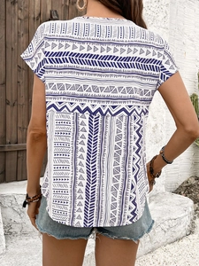Back view of a Bohemian blouse with blue geometric patterns and casual denim shorts