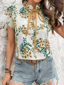 Detail of vintage floral print blouse with ruffled collar and mustard yellow neck tie