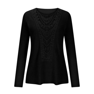 Detail of black waffle knit long sleeve top featuring intricate lace V-neck patchwork