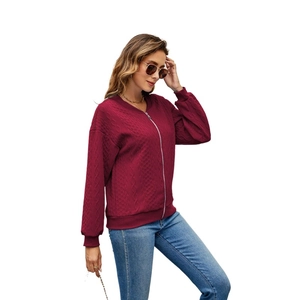 Detailed view of wine red zip-up jacket with textured diamond quilting and ribbed cuffs