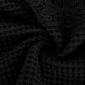 Detail of floral lace trim and textured waffle knit fabric on black sleeveless top