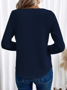 Dettaglio della trama a nido d'ape blu scuro e taglio posteriore sulla maglia a maniche