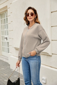Detailed relief texture on a light brown zip-up knit cardigan for women