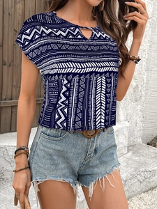 Close-up of geometric tribal patterns and V-neck detail on navy bohemian shirt