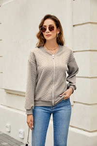Detailed view of cable-knit zip-up jacket with ribbed cuffs and silver metal zipper