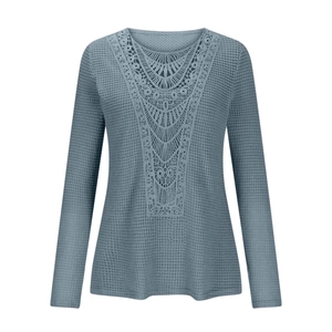 Detailed close-up of blue waffle knit texture and intricate lace embroidery on the V-neckline