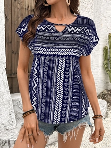 Detail of bohemian geometric print on navy blouse with delicate V-neck hollow-out design