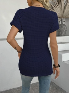 Detail of navy blue knit top with intricate hollow lace texture on back and sleeves