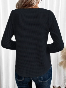 Vista posteriore della maglia nera a maniche lunghe in maglia a nido d'ape con bordo curvo
