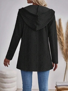 Rear view of black hooded cable knit cardigan with long sleeves and thick textured fabric