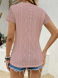 Dettaglio della maglia a rombi traforata e pizzo sugli orli della maglietta rosa donna