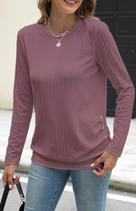 Detail shot of the ribbed texture and gold buttons on the hem of this casual knit top