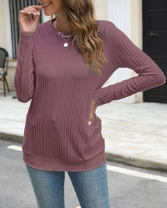 Detail showing purple ribbed knit fabric texture and sleeve buttons on long sleeve shirt