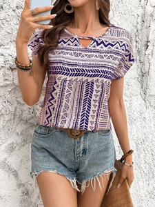 Detail of bohemian geometric print on navy blouse with cut-out neckline and tassels