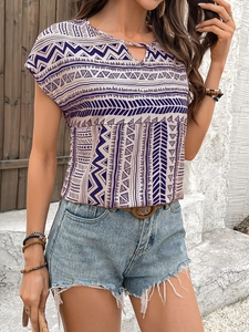 Detail view of women's boho geometric print top with hollow V-neck and denim shorts