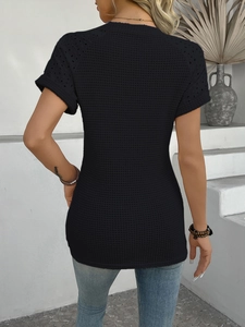 Detail showing the intricate hollow eyelet knit pattern and back of the black short sleeve top