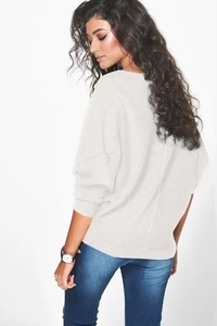 Détail du pull en maille blanc oversize à manches chauve-souris avec texture côtelée au dos