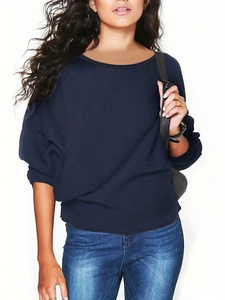 Détail d'un pull en maille bleu foncé montrant le col rond et la texture tricotée
