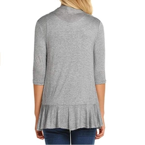 Detail view of grey cardigan featuring a stylish ruffled hem and premium soft knit fabric
