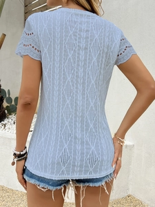 Dettaglio del top a maniche corte azzurro con texture geometriche all'uncinetto