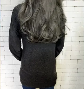 Rear view of loose dark grey long-sleeve knit top featuring functional side pockets
