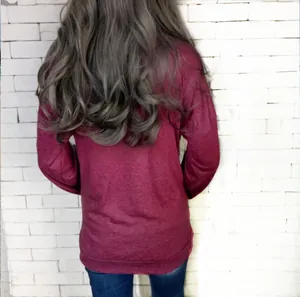Back view of a casual burgundy long sleeve crewneck top with pockets and jeans