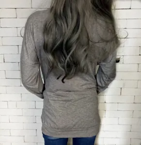 Rear view of long sleeve light gray knit top featuring a loose fit and casual style