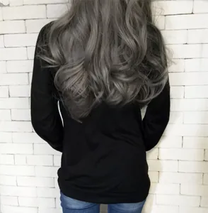 Close-up back view of long wavy silver gray wig with voluminous curls on woman