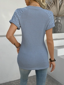 Detail of the back view of a light blue knitted top showing lace hollow-out shoulder design