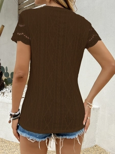 Dettaglio del motivo a uncinetto traforato sulla t-shirt marrone a maniche corte donna