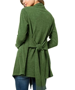Détail d'un gilet en maille vert foncé avec un grand nœud papillon à lacets dans le dos