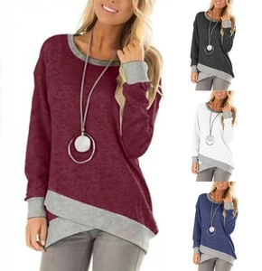 Detail of asymmetrical overlapping hem and color-block ribbed cuffs on long sleeve top