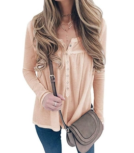 Detail of waffle knit fabric and buttoned henley neckline on a loose long sleeve top