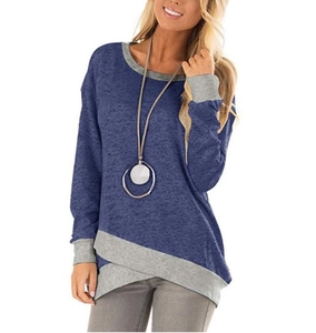 Detail of blue crewneck top with asymmetrical layered hem and grey patchwork cuffs