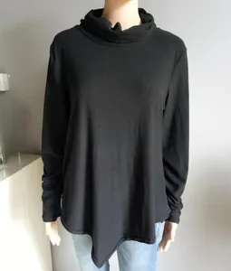 Detail of black long sleeve top featuring a high cowl neck and irregular hemline design