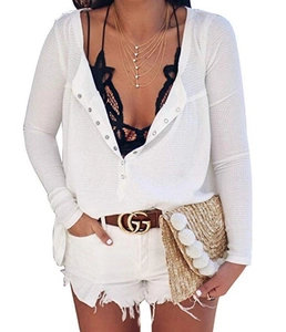 Detail of white waffle knit texture and buttoned sleeves on a long-sleeve cardigan top