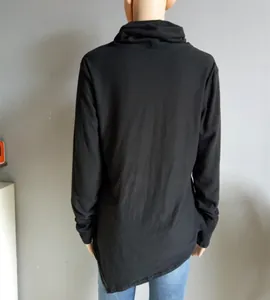 Detailed back view of a slim fit black turtleneck top with unique asymmetric hemline