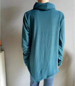 Detail of dark teal long sleeve top with an asymmetrical irregular pointed hem design