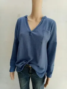 Detailed close-up of light blue waffle knit fabric featuring a V-neck and chest pocket