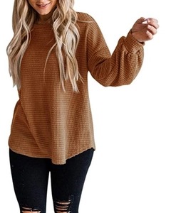 Detailed macro view of the caramel waffle knit fabric and ribbed lantern sleeve cuffs