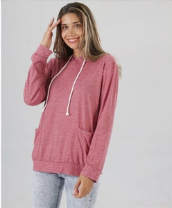 Dettaglio del tessuto della felpa rosa con cappuccio a coulisse e tasche frontali