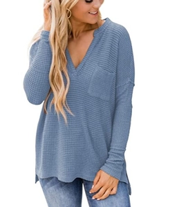 Detail of blue waffle knit fabric on V-neck long sleeve top with side slits and pocket