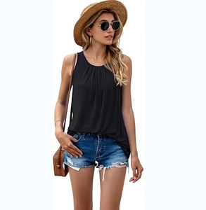 Detail of a black sleeveless vest with pleated neckline paired with summer denim shorts