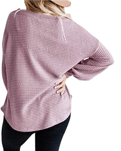 Detailed macro view of soft waffle knit texture on a mauve casual lantern sleeve top