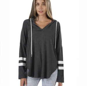 Detail view of dark grey hoodie with V-neckline, white drawstrings and striped cuffs