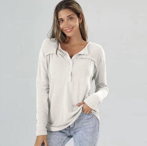 Detailed view of women's waffle knit long sleeve top with henley button neckline
